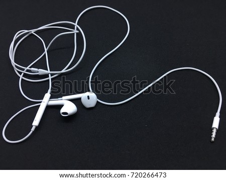 White earphones on black screen background