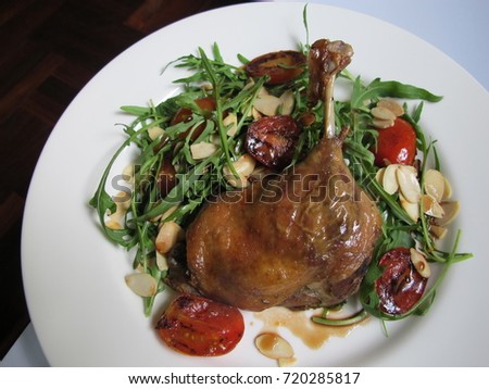 homemade food, classic french cuisine...duck confit served with arugula salad and bake tomato with balsamic dressing
