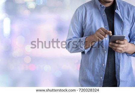 person holding a smartphone on blurred cityscape background