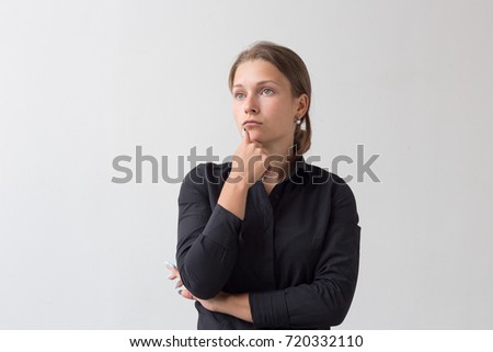 Portrait of thinking young business woman in black shirt