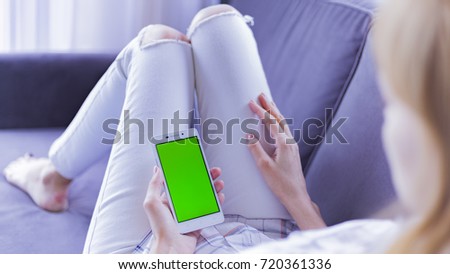 The smartphone in the hands of a young woman