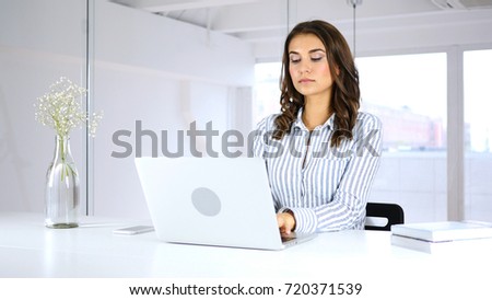 Serious Woman Working On Laptop in Office
