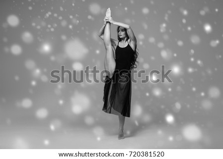 People, art, Ballet dancer woman black dress on gray background winter snowflakes. Black and white.