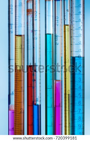 background with pipettes filled with colored liquids / serological pipettes with colored fluid samples Royalty-Free Stock Photo #720399181