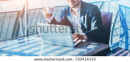 businessman working on computer, drinking coffee and smiling, abstract business banner background with place for text