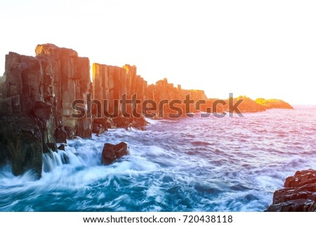 Basalt wall and ocean view, wave breaking with rock formations at headland in Kiama, New South Wales, Australia