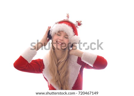 A young blonde beautiful girl wears a Santa Claus suit and has headphones on her head.
She enjoys listening to the Christmas carols she hears on the radio.