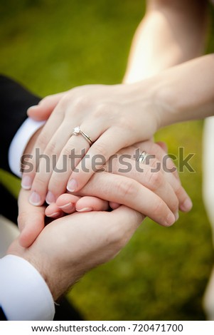 Beautiful, simple picture showing a brand new couple holding hands with gorgeous wedding rings.