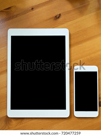 smart phone and tablet  in white color. Black screen for mockup put on wood background