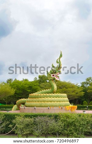 giant statue of King of Nagas (a big snake) larger than human scale size, Krabi, Thailand. Flowers are brought by the worshippers. Religious belief.