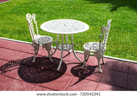 Iron tables and chairs on the lawn.