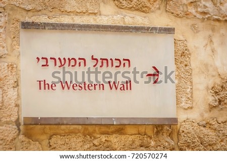 A direction sign board to the Western wall in Hebrew and English somewhere in the street of the Old city Jerusalem. Tisha B'Av, Yom Kippur