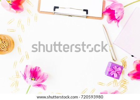 Beauty blog composition. Freelancer or blogger desk with clipboard, notebook, pink tulips and accessories on white background. Flat lay, top view.