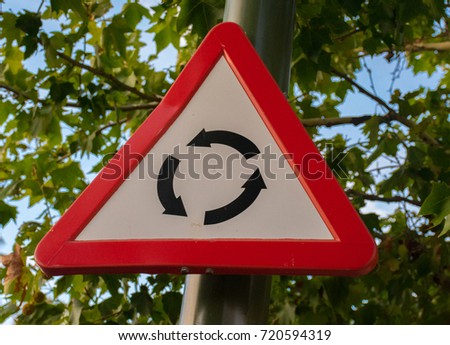 Triangular roundabout road sign for indication of it ahead to automobiles and cars.