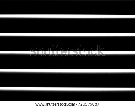 White cylindrical lines with fine dust particles on a black background. Abstract texture, black and white drawing. Geometric shapes, zebra pattern. The effect of blinds.