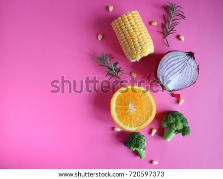 Fresh and colorful vegetables and fruits on a pink background. Space for text. Top view.