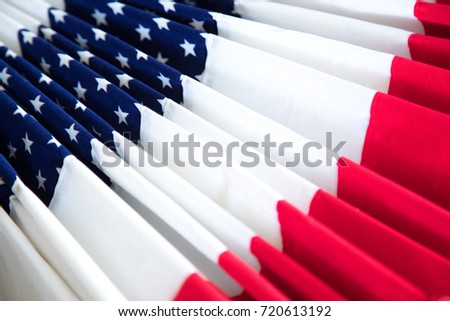 Oblique perspective of American patriotic fan or bunting made of folded fabric with red and white strips, beside blue star pattern, as a Veterans Day decoration