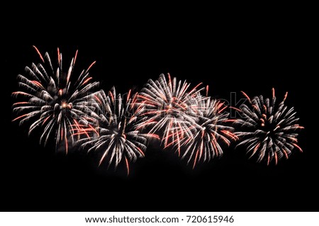 White and pink fireworks display on dark sky background.