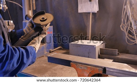 Craftsman sawing metal with disk grinder in workshop. Metal sawing close up. Worker in production sawing metal. Industry in slow motion