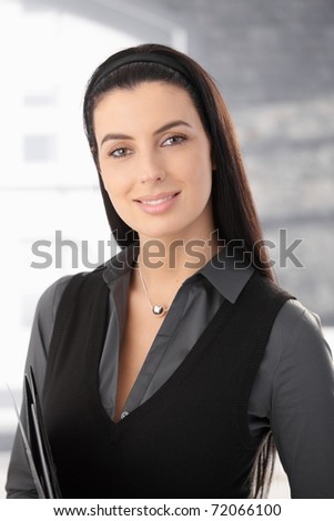 Portrait of long dark hair smart woman smiling at camera.?