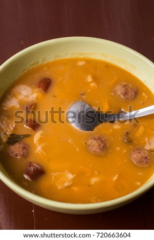 Closeup macro angle of cooked beans with sausages served in the bowl.