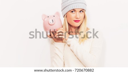 Young woman with a piggy bank on a white background