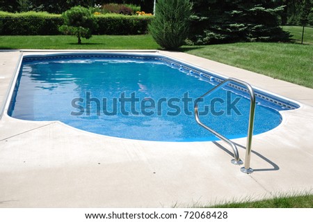 Backyard In-Ground Swimming Pool on a Sunny Summer Day Royalty-Free Stock Photo #72068428