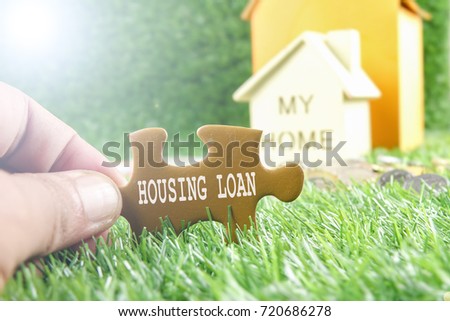 Small house on the green background with HOUSING LOAN words. Housing/real estate concept.