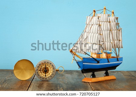 Columbus day concept with old ship over wooden background.