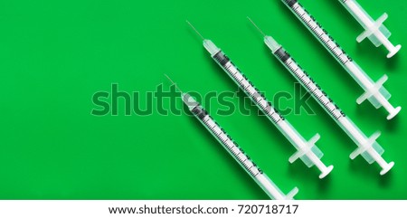 5 syringes on a green background