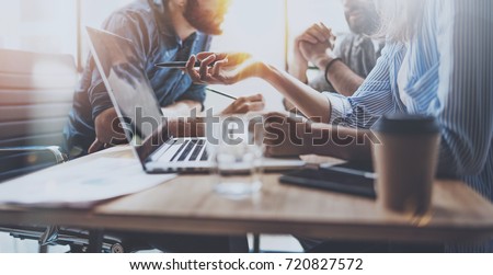 Brainstorming process at sunny office.Young coworkers work together modern office studio.Young people making conversation at wooden table.Horizontal wide.Blurred background Royalty-Free Stock Photo #720827572