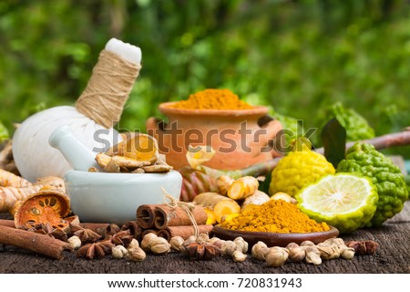 Turmeric powder,Turmeric in Mortar Grinder drugs and ingredient herbs on wooden background Royalty-Free Stock Photo #720831943