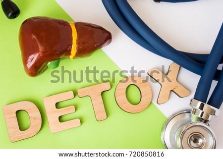 Liver detox concept photo. Word detox of volumetric letters is near 3D liver model and  medical stethoscope. Medical diet program for detoxification and cleanse of biliary system for women and men Royalty-Free Stock Photo #720850816