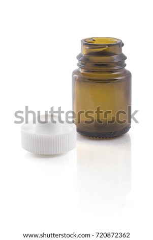 Empty brown glass jar and plastic cover next to on white background  