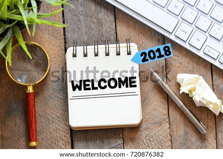 Welcome 2018 on paper note book background