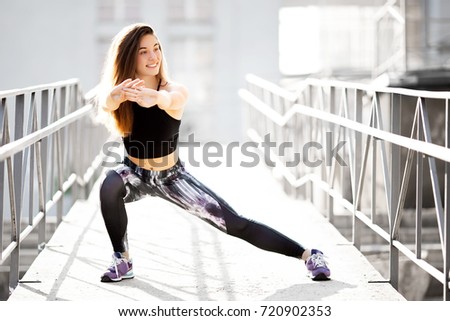 Beautiful sport fitness girl in sportswear doing fitness exercise in the street ,outdoor sports. Urban style.
