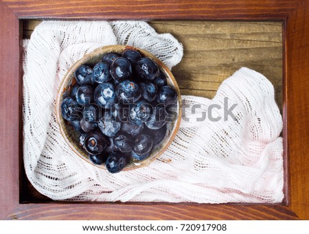 Blueberry fruit in a bowl in a wooden picture frame