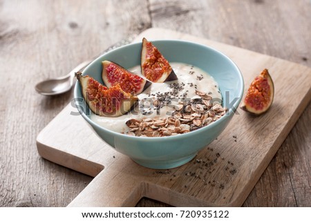 healthy breakfast. muesli, yoghurt, figs, chia seeds in a blue bowl ha old wooden background Royalty-Free Stock Photo #720935122