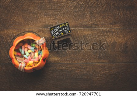 Aerial view of accessory decoration Happy Halloween festival background concept.Mix object on modern rustic brown wooden at home office desk.trick or treat
bowls and candy for ornament the season.