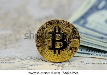 Golden Bitcoins on banknotes background.Photo of golden bitcoin (new virtual currency)