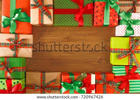 Packaging modern christmas presents. Gift boxes frame on wooden background. Christmas and winter holidays concept. Top view, flat lay, copy space