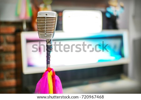 Old microphone with multicolored tie