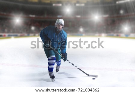ice hockey player in action kicking with stick in front of big modern hockey arena with lights and flares