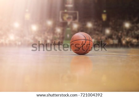 Basketball ball,  board and net in front of big modern basketball arena