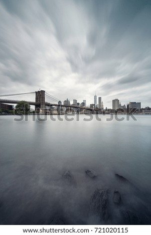 Brooklyn bridge and Manhattan skyline at sunset in a cloudy day