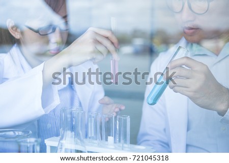 Scientist colleagues have an experimental in a laboratory.