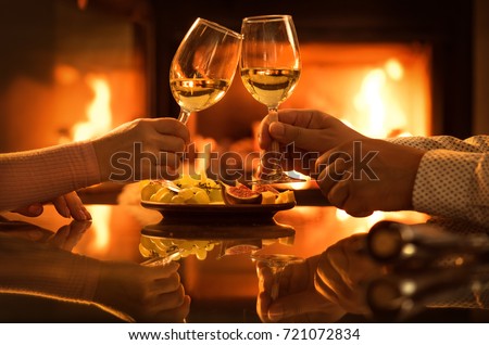 Young couple have romantic dinner with wine over fireplace background. Romantic concept .