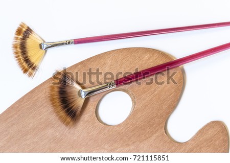 Painting brushes and palette isolated on white background. waiting for the artist, unused painting brushes and palette. Artists palette