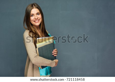 Smiling girl student or woman teacher portrait on gray wall. Royalty-Free Stock Photo #721118458