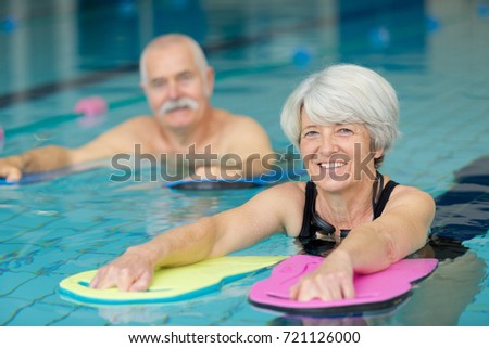portrait of senior man and woman in swimming pool Royalty-Free Stock Photo #721126000